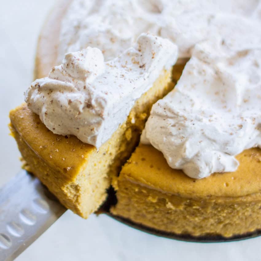 pumpkin cheesecake with gingersnap crust topped with cinnamon whipped cream