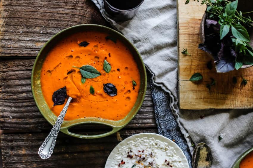 bowl of fresh tomato soup and bowl of fresh basil
