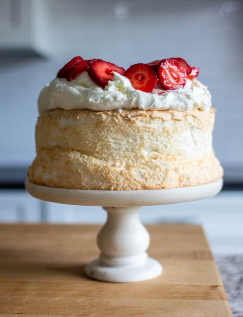 gluten-free angel food cake recipe topped with strawberries and cream