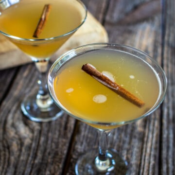 Two apple martinis on a wooden background