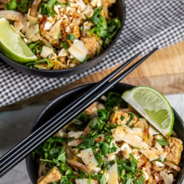 two bowls of pad thai on light background