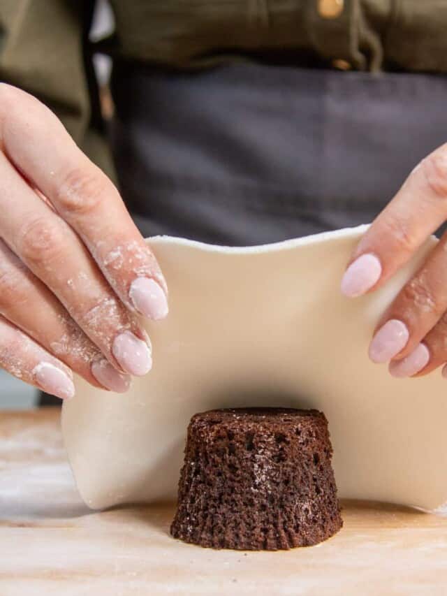 hand placing fondant on to cake