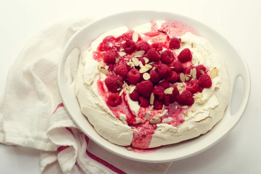 best pavlova recipe topped with cream and berries