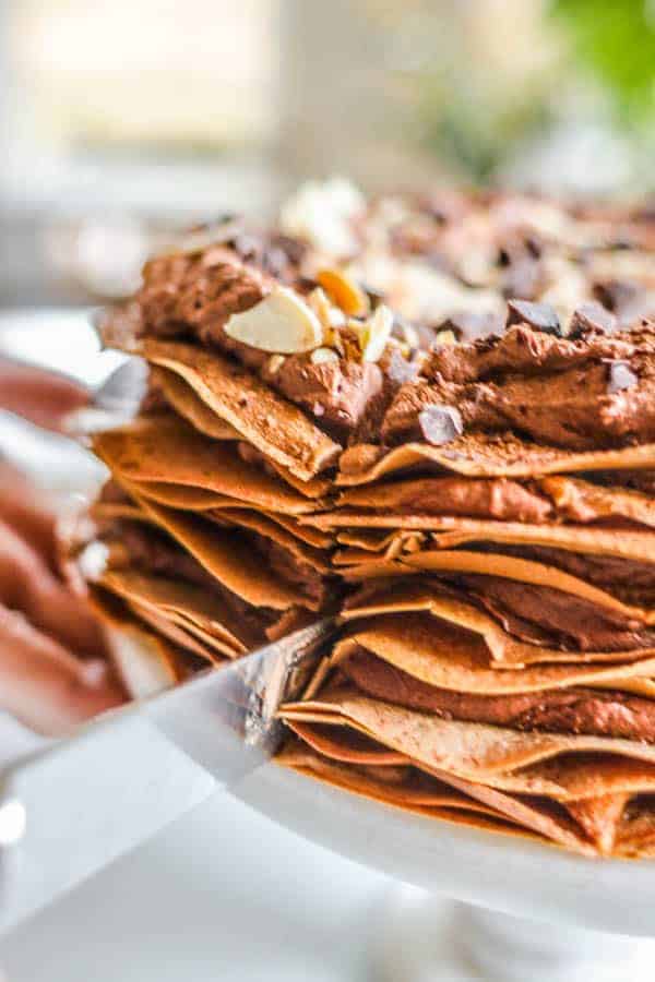 taking a slice of chocolate crepe cake