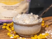 A bowl of cornstarch on a wooden cutting board