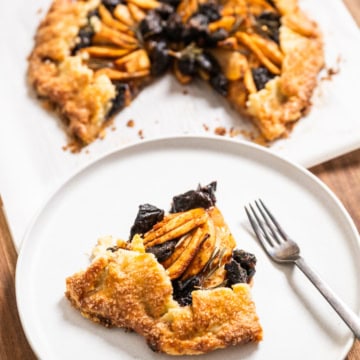 slice of Apple & Prune Galette recipe with full galette behind