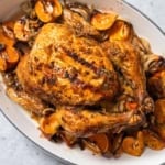 Looking down over a roasted chicken with mandarins and onions.