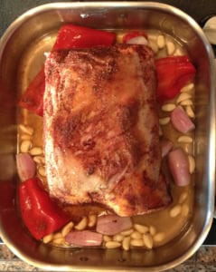 raw lamb shoulder roast in pan with garlic shallots and wine