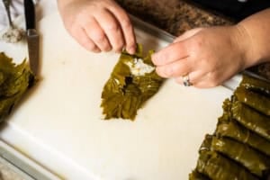 rolling a grape leaf with rice filling