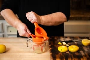 squeezing lemon juice into a glass container